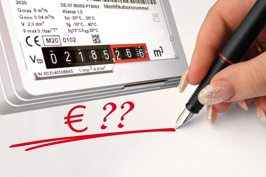 Gaszähler mit Euro-Zeichen und Fragezeichen. Hand hält einen Stift darüber.